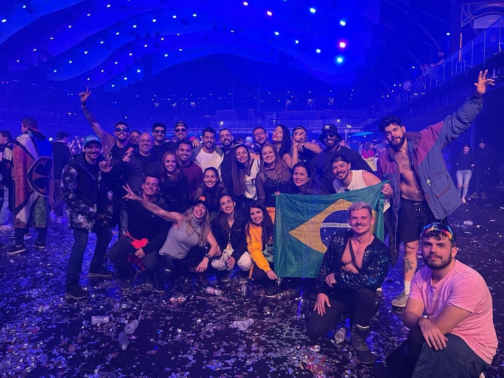 Grupo da Never Ends com a bandeira do Brasil dentro do Mainstage coberto da Tomorrowland Winter, com o teto inteiro iluminado de azul