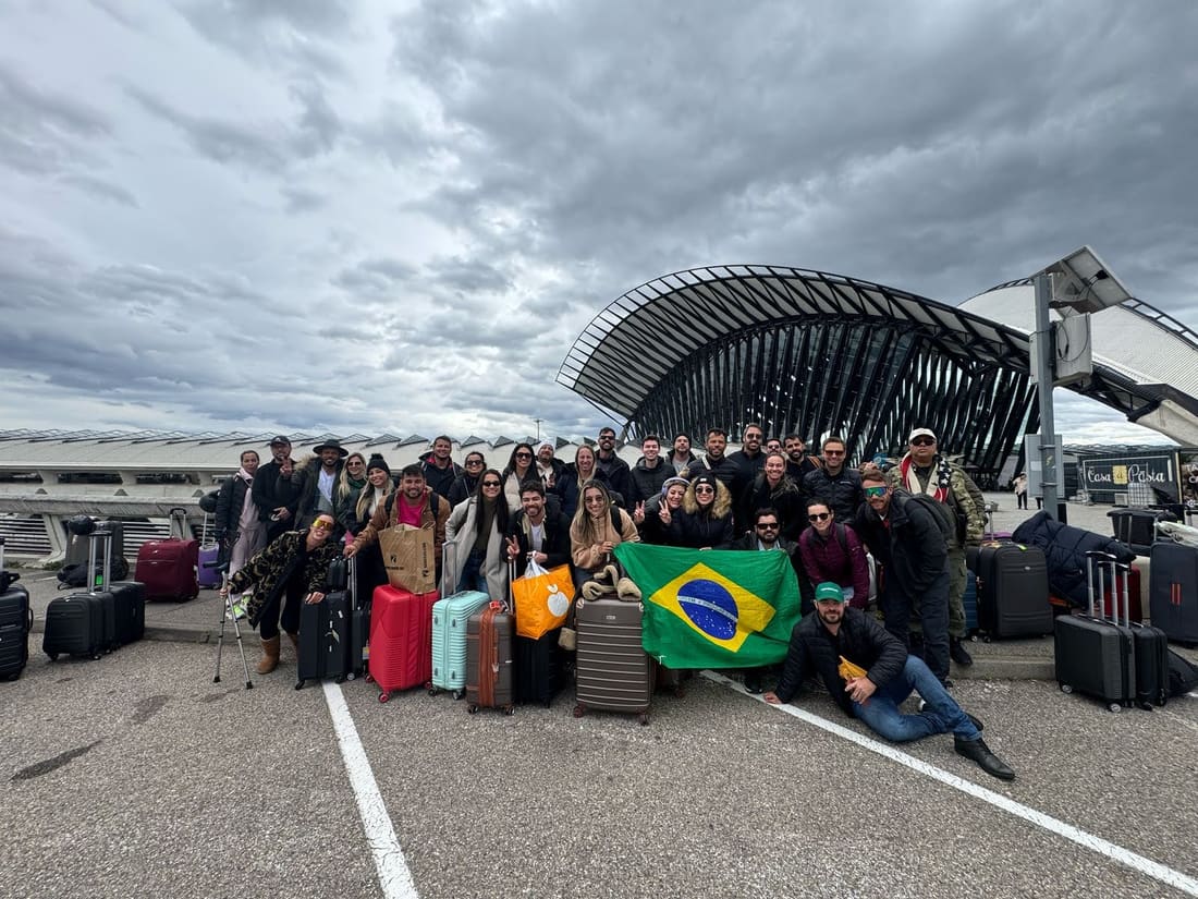 Grupo da Never Ends com as malas e a bandeira do Brasil na chegada ao aeroporto de Lyon, a caminho de Alpe d'Huez
