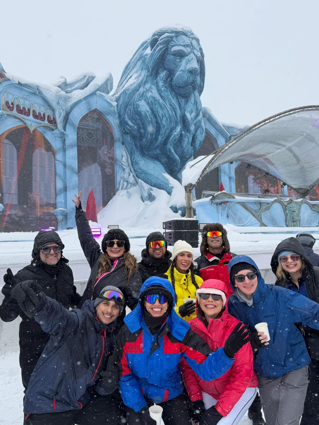 Grupo da Never Ends debaixo de neve caindo diante do Snow Lion, o leão de gelo do palco Orbyz da Tomorrowland Winter